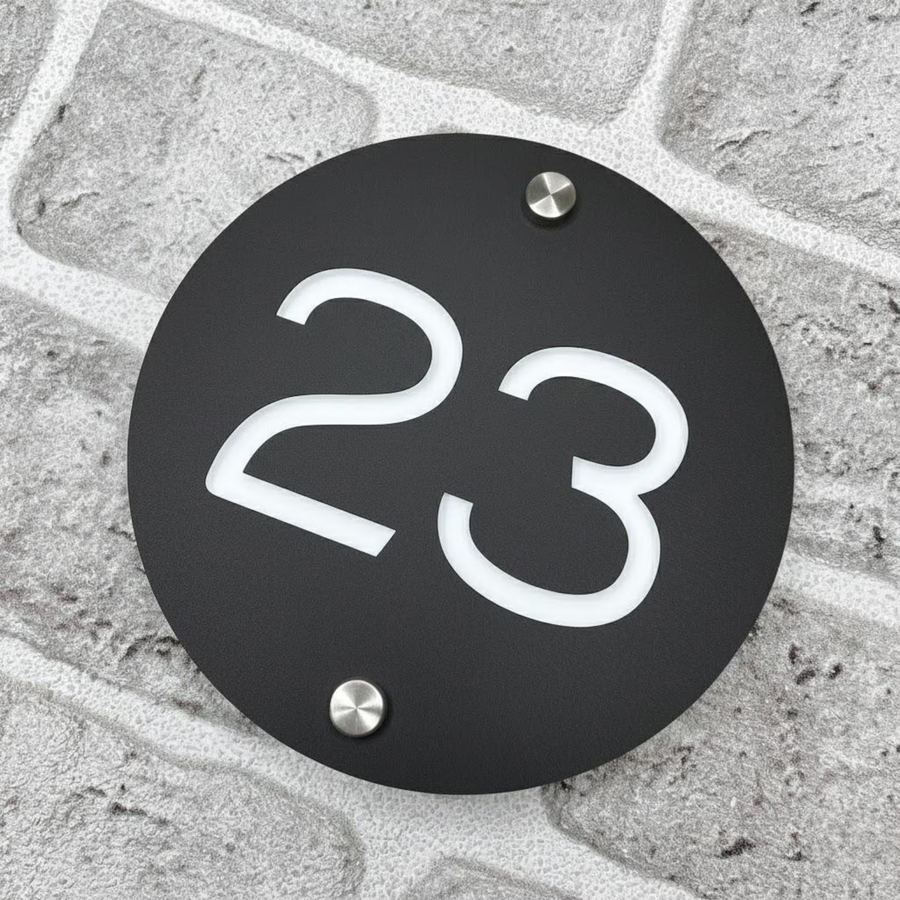Round acrylic house number sign on brick